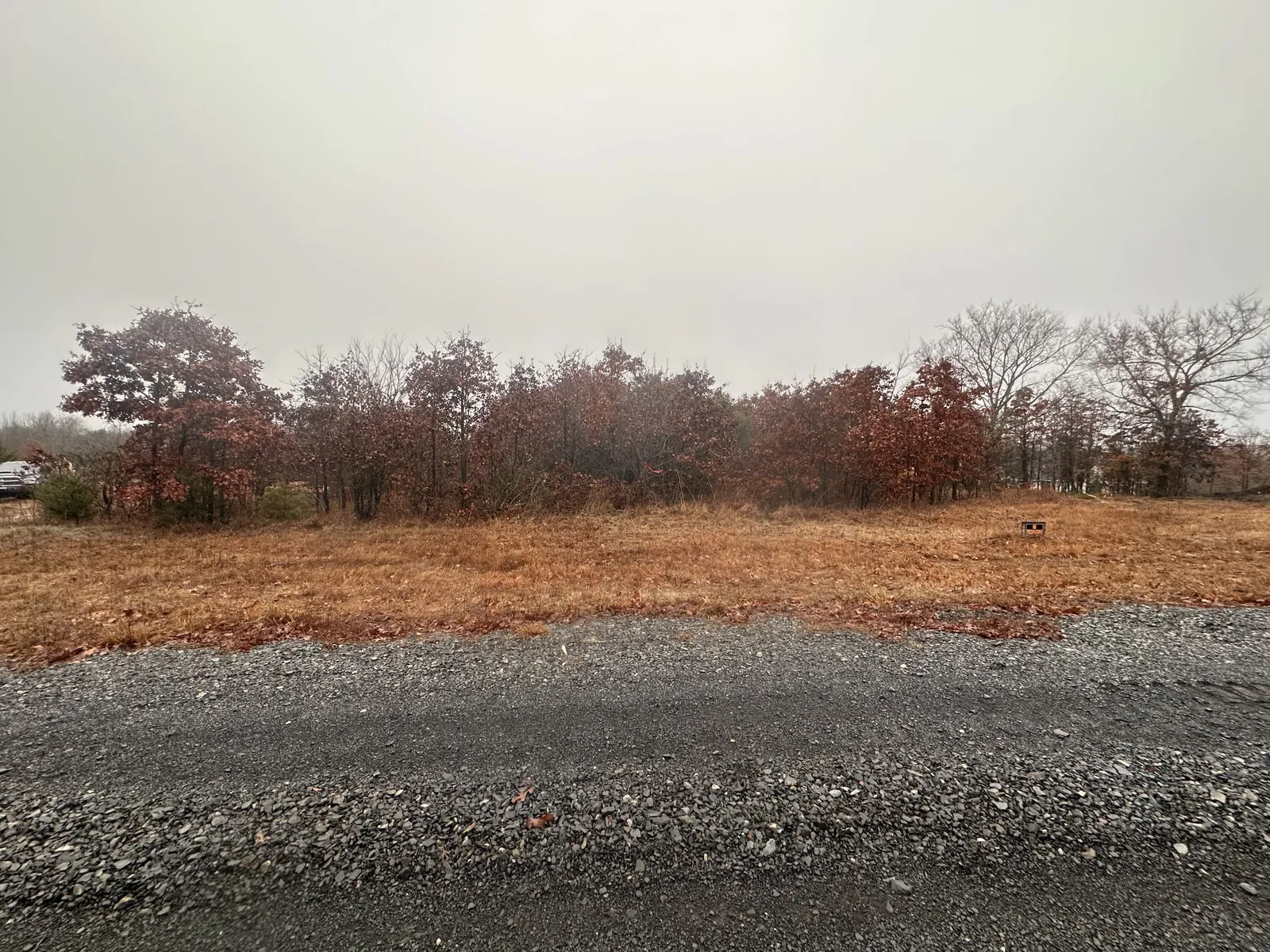 Cleared lot down to workable dirt by a gravel road