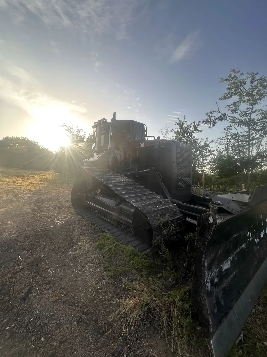 Cat D6 dozer staged on cleared ground at first light
