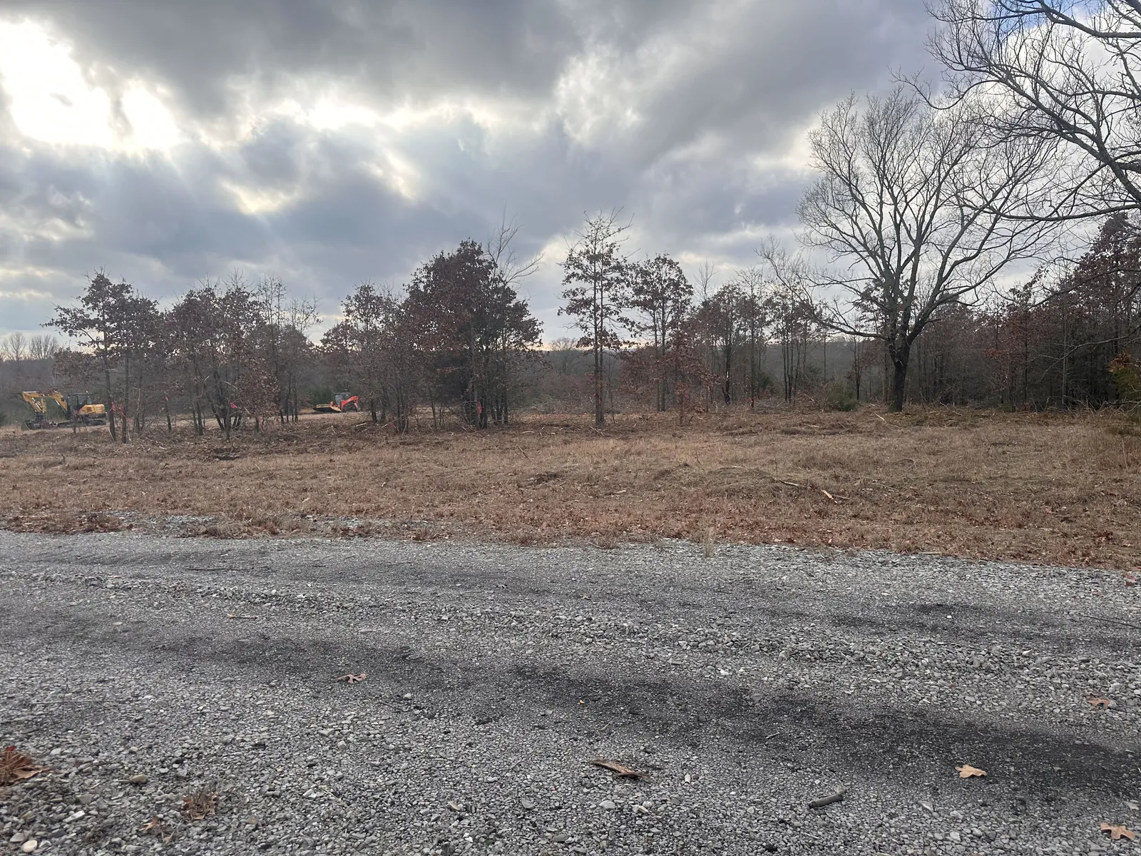 Gravel pad set on a cleared site under a moody sky