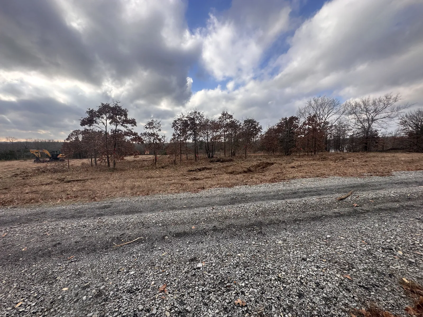 Cleared land beside a fresh gravel drive on an Oklahoma property after mechanical land clearing
