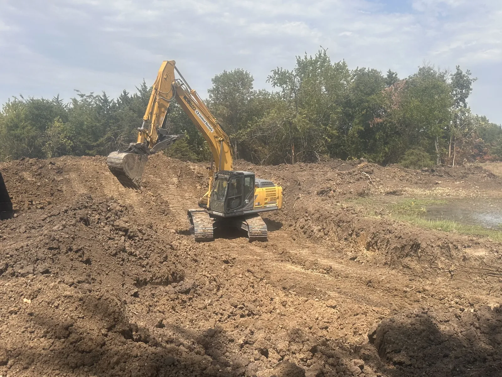 Our excavator digging on an Oklahoma job, the machine that opens the hole for an in-ground storm shelter